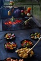 Vegetables and potatoes being on a large cast iron grill.